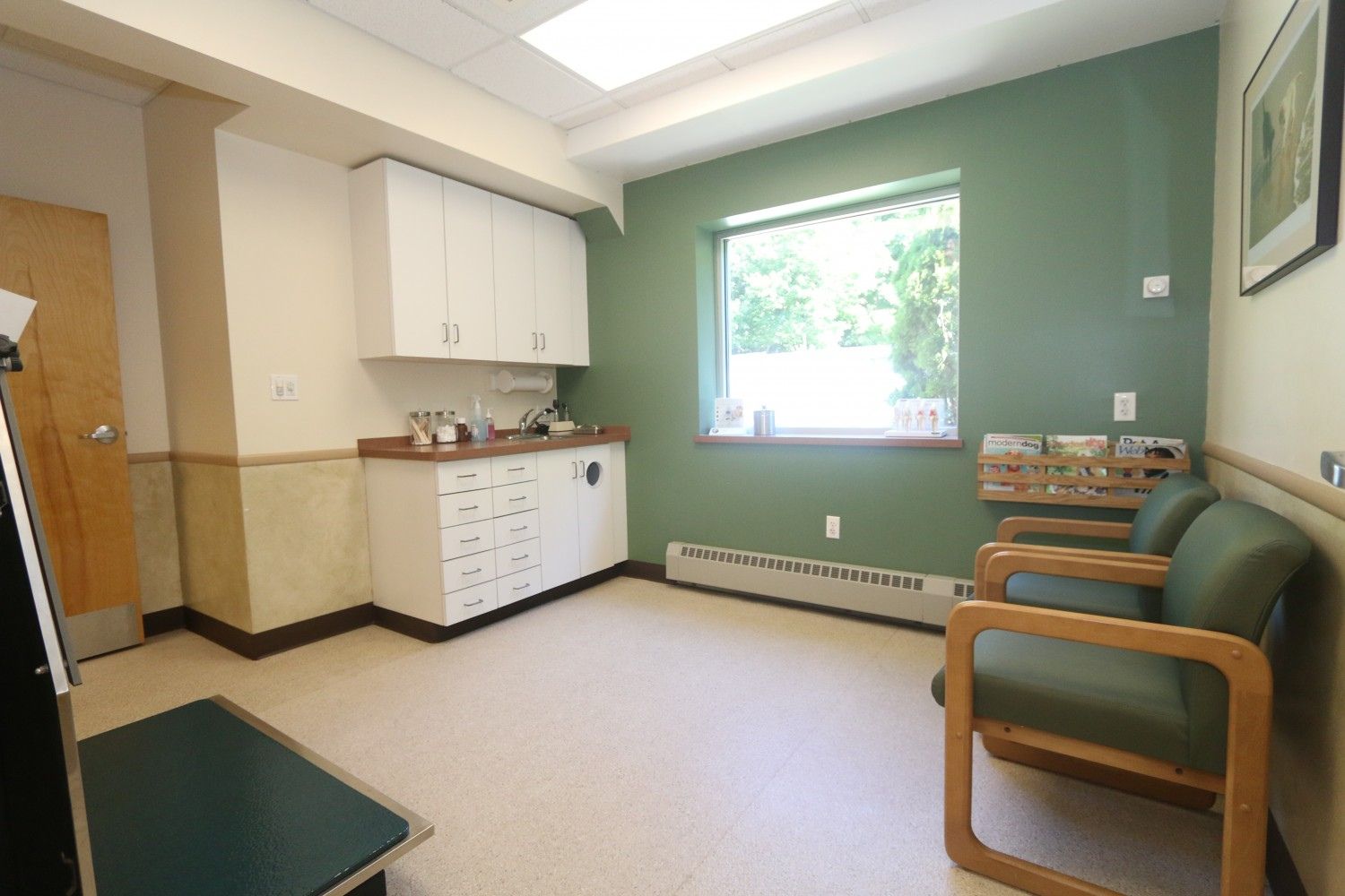an empty room with green walls and white cabinets